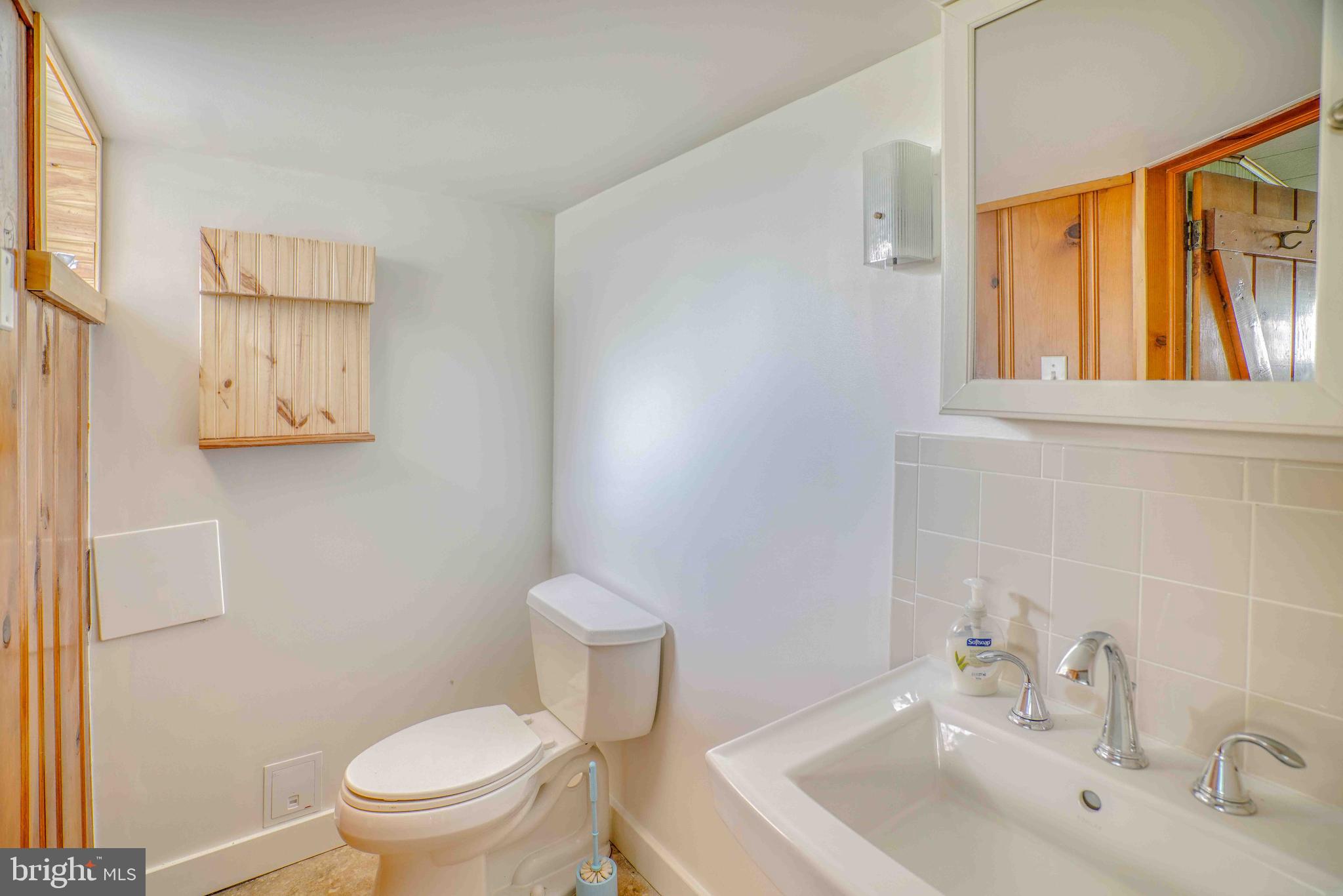 1136 Kerper Street Philadelphia, PA 19111 - Photo 35 of 41 a bathroom with a sink a mirror and a toilet