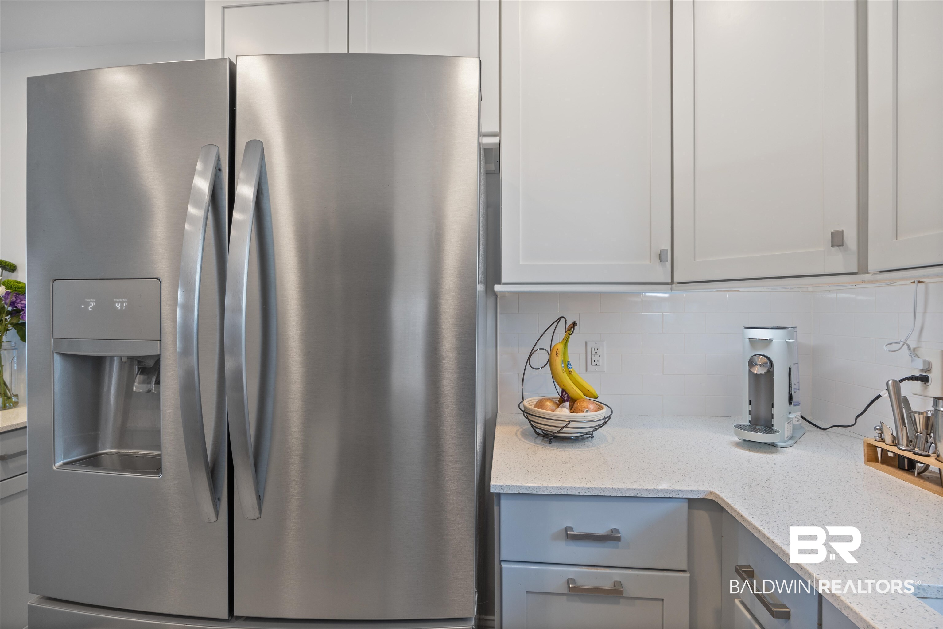 14100 River Road, Unit 327B Perdido Key, FL 32507 - Photo 11 of 46 Kitchen featuring stainless steel refrigerator with ice dispenser, light stone counters, decorative backsplash, and gray cabinetry