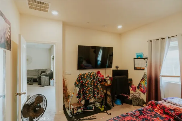 a bedroom with a bed and a refrigerator