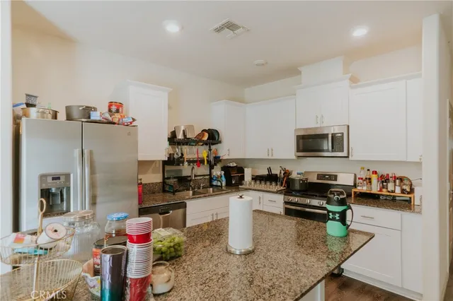 a kitchen that has a lot of cabinets a sink and appliances in it