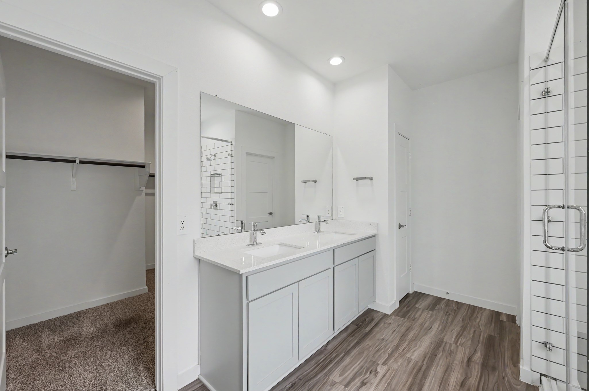 14162 Primrose Ridge Lane Conroe, TX 77384 - Photo 29 of 48 Modern bathroom featuring a sleek double vanity, spacious walk-in closet, and elegant glass-enclosed shower.