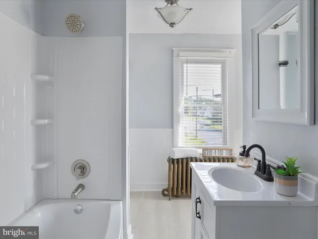 a bathroom with a sink a tub and a window