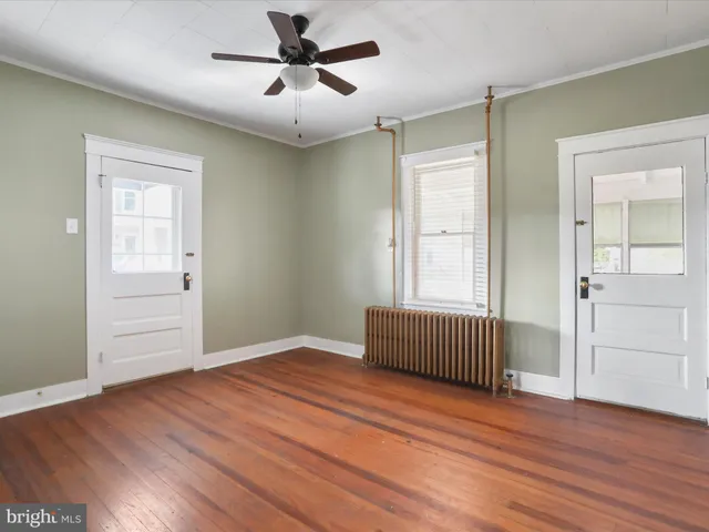 a view of empty room with wooden floor