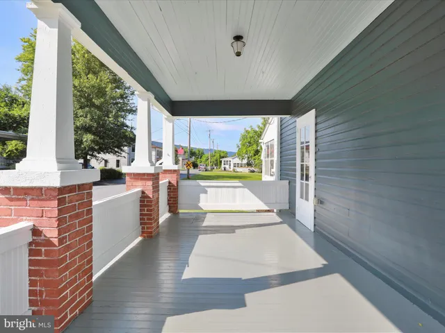 a large white kitchen with wooden floors and stainless steel appliances