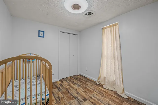 a view of a bedroom with wooden floor