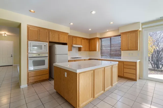 a kitchen with stainless steel appliances granite countertop a stove a sink and a refrigerator