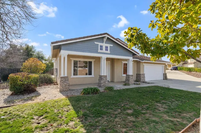 a front view of a house with a yard and outdoor seating