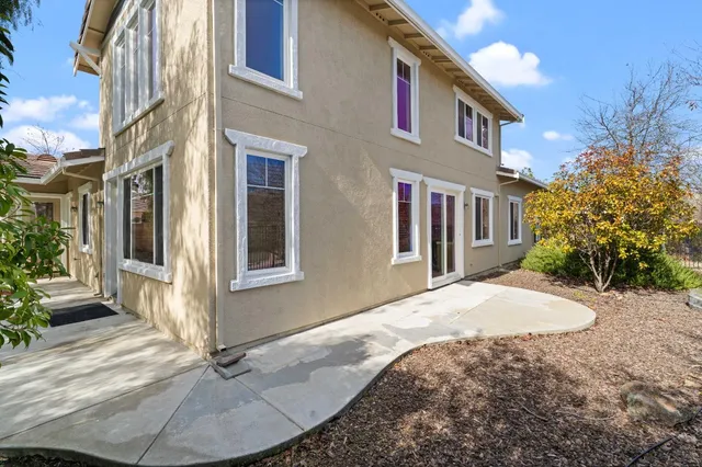 a view of a house with backyard and trees around