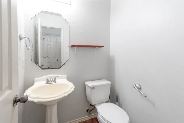 a bathroom with a toilet sink and mirror