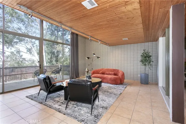 a living room with furniture and a floor to ceiling window
