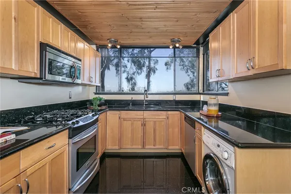 a kitchen with stainless steel appliances granite countertop a stove a refrigerator and a sink