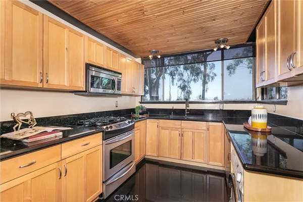 a kitchen with stainless steel appliances granite countertop a stove microwave and refrigerator