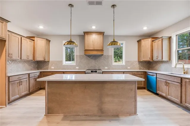 a large kitchen with kitchen island a stove a sink a center island and living room view