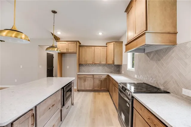 a kitchen with a sink dishwasher a stove and a refrigerator with wooden floor