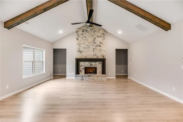 a view of an empty room with a fireplace and a window