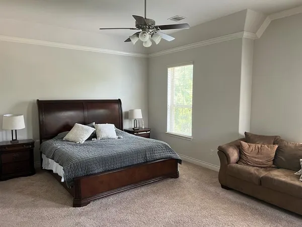 a bedroom with a bed couch and window
