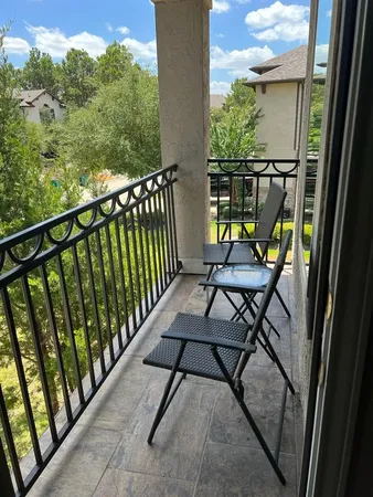a view of a chairs and table in the balcony
