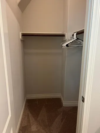 an empty walk in closet with wooden floor