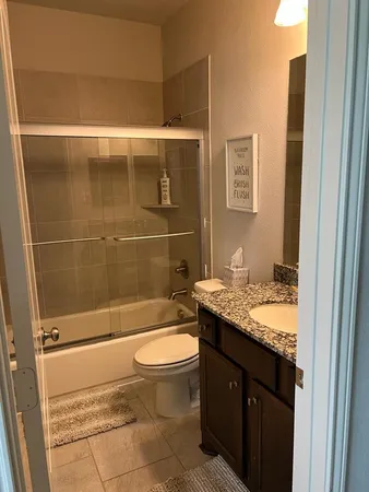 a bathroom with a granite countertop sink toilet and shower