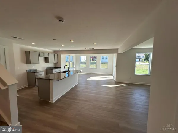 a living room with stainless steel appliances kitchen island wooden floors and view living room