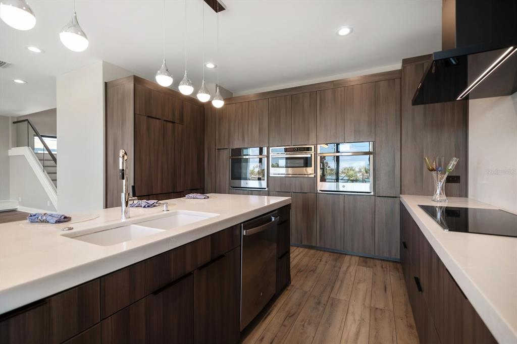 16047 Redington Drive Redington Beach, FL 33708 - Photo 19 of 80 a kitchen with kitchen island granite countertop a sink and wooden cabinets