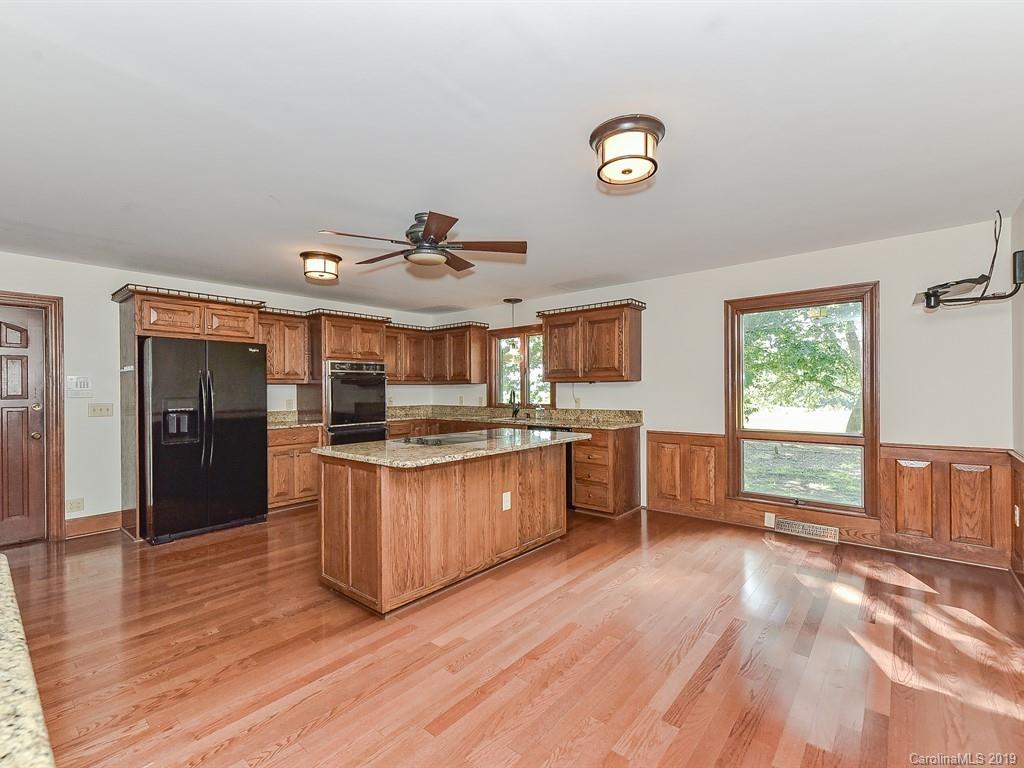 402 3 Knotts Road Monroe, NC 28112 - Photo 13 of 48 a kitchen with granite countertop a stove a sink a refrigerator and wooden floor