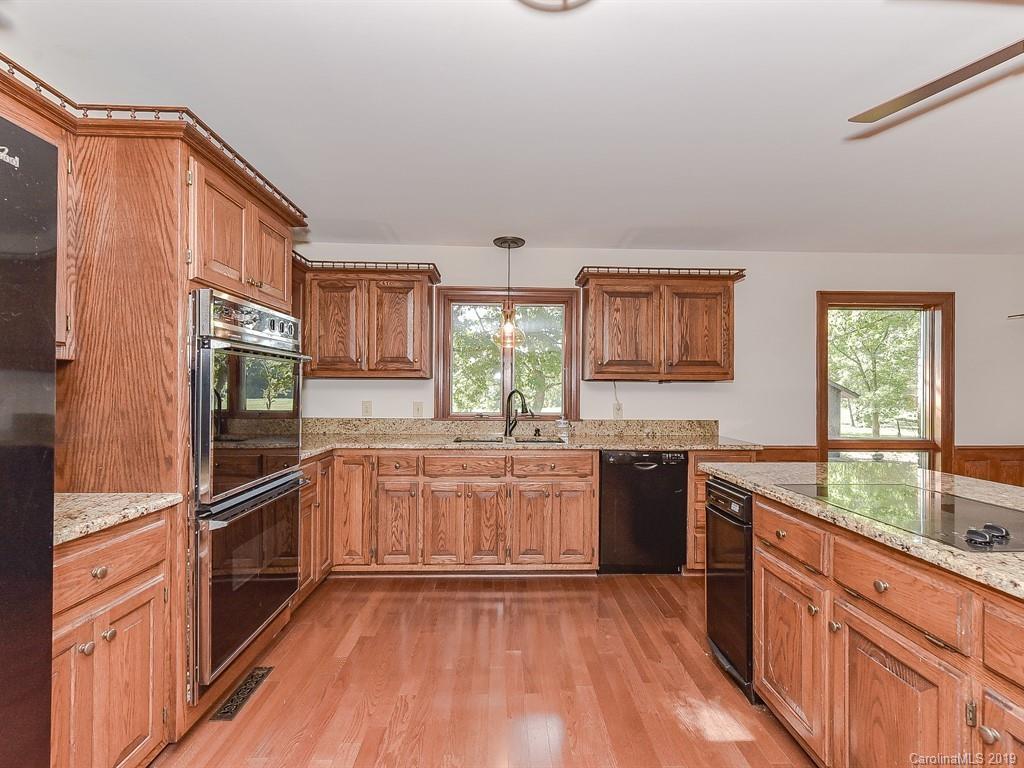 402 3 Knotts Road Monroe, NC 28112 - Photo 15 of 48 a kitchen with stainless steel appliances granite countertop a stove a sink dishwasher a refrigerator and wooden cabinets