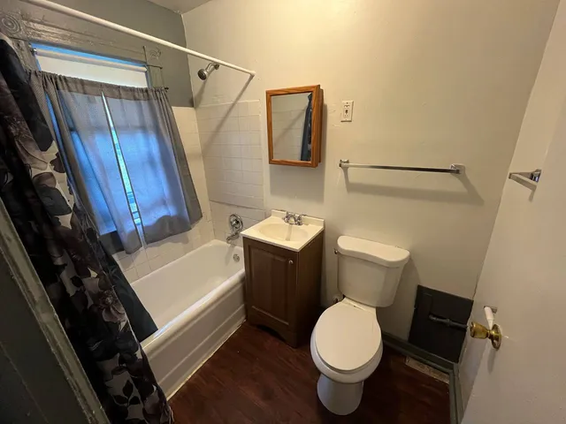 a white toilet sitting next to a bathroom sink and a mirror