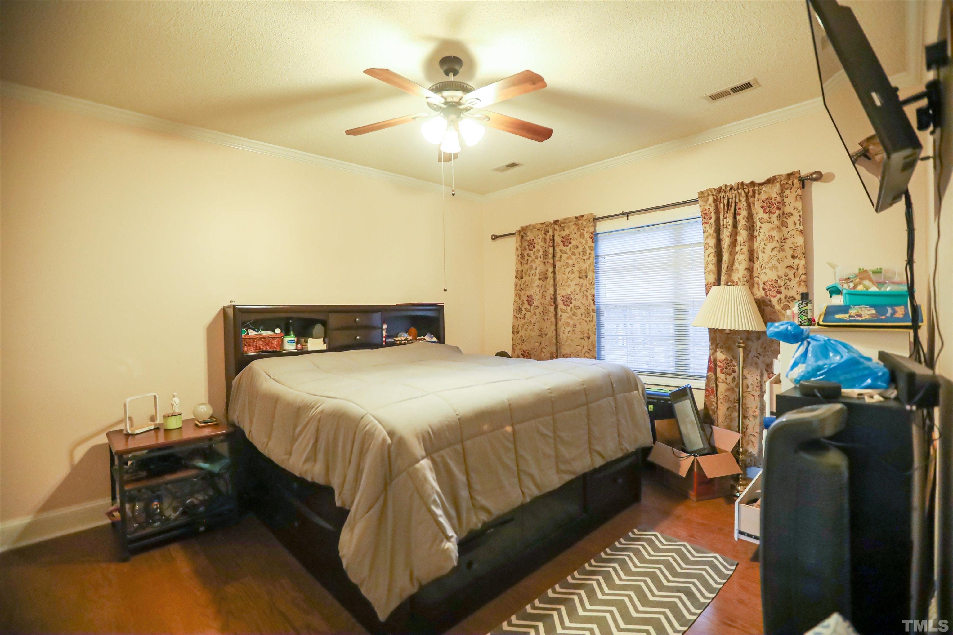 4102 Beaufain Street Raleigh, NC 27604 - Photo 19 of 28 a bedroom with a bed and wooden floor