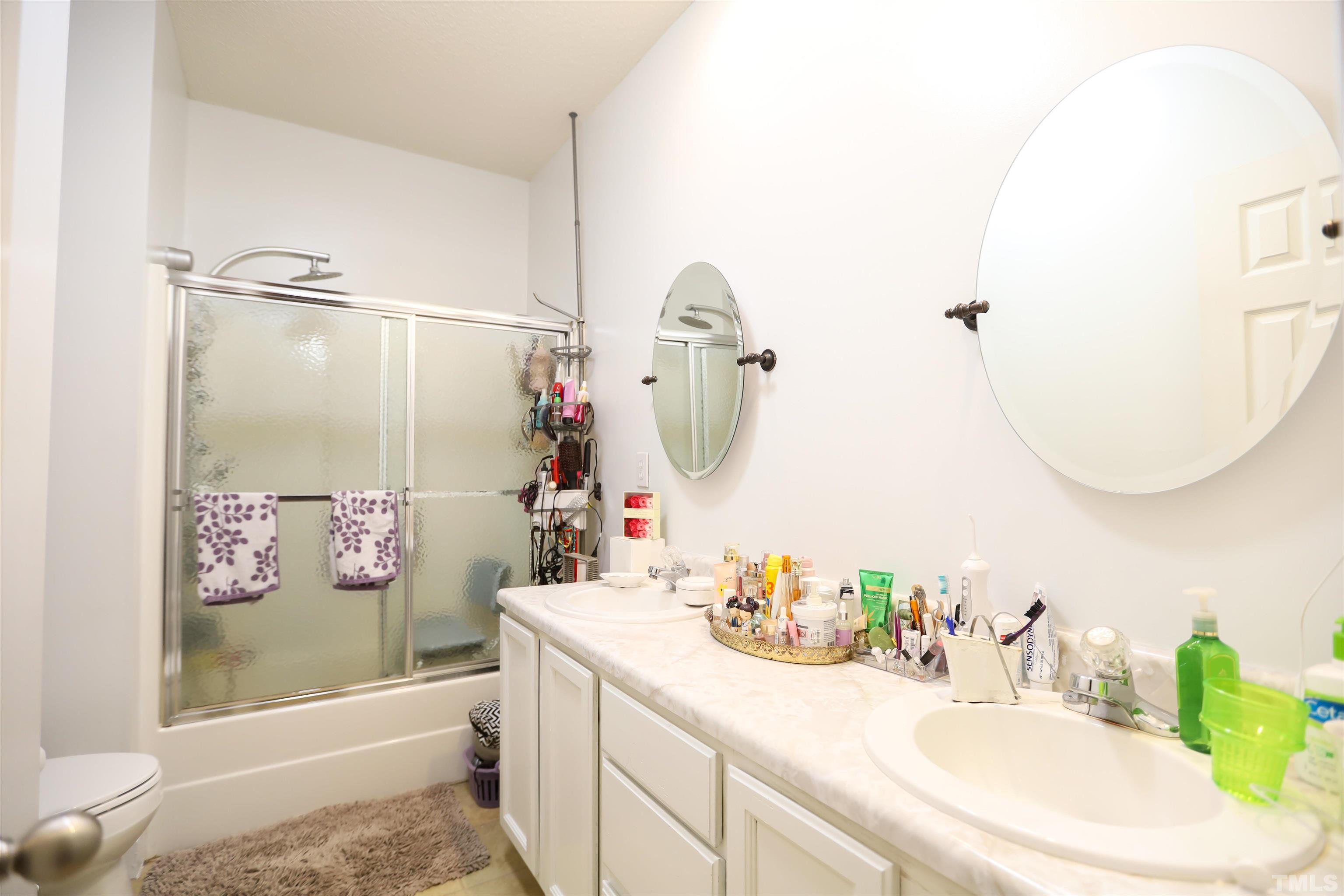 4102 Beaufain Street Raleigh, NC 27604 - Photo 20 of 28 a bathroom with a sink mirror and a bathtub