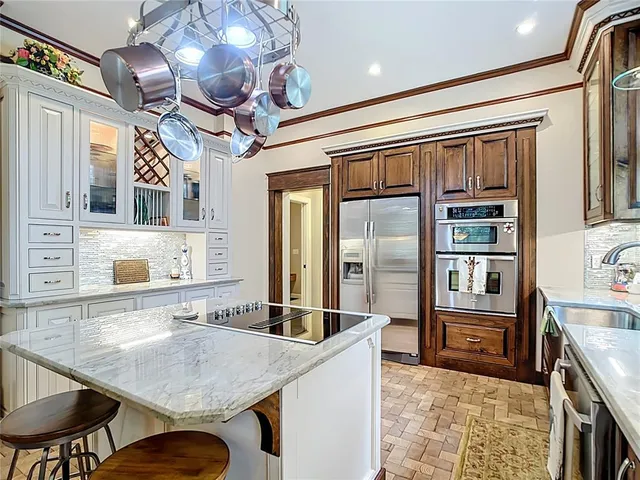 a kitchen with stainless steel appliances granite countertop a sink refrigerator and cabinets