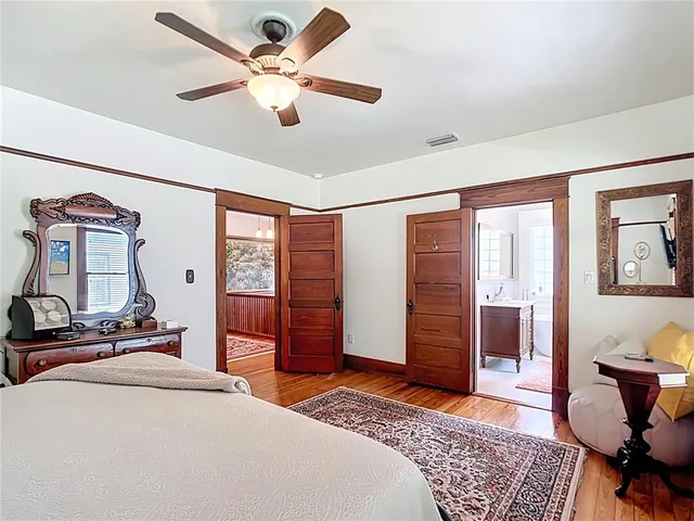 a bedroom with a bed and dresser with chair