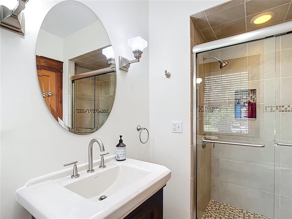 705 Southeast 5th Street Ocala, FL 34471 - Photo 30 of 41 a bathroom with a sink a mirror and a shower