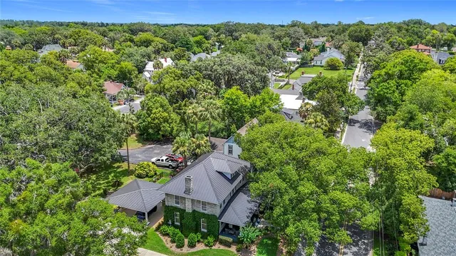 an aerial view of residential houses with outdoor space and trees