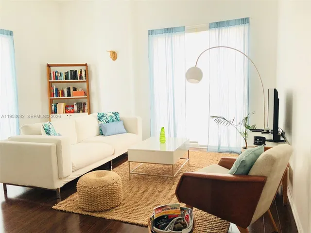 a living room with furniture and wooden floor