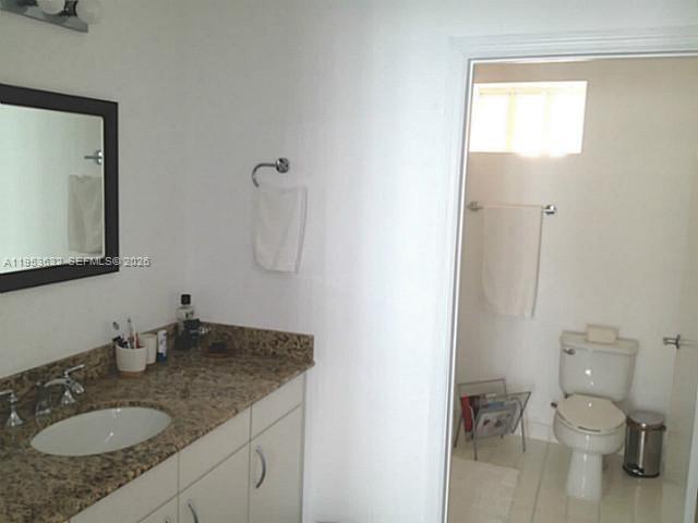 7290 Southwest 90th Street, Unit 701 Miami, FL 33156 - Photo 11 of 16 a bathroom with a granite countertop sink toilet and shower