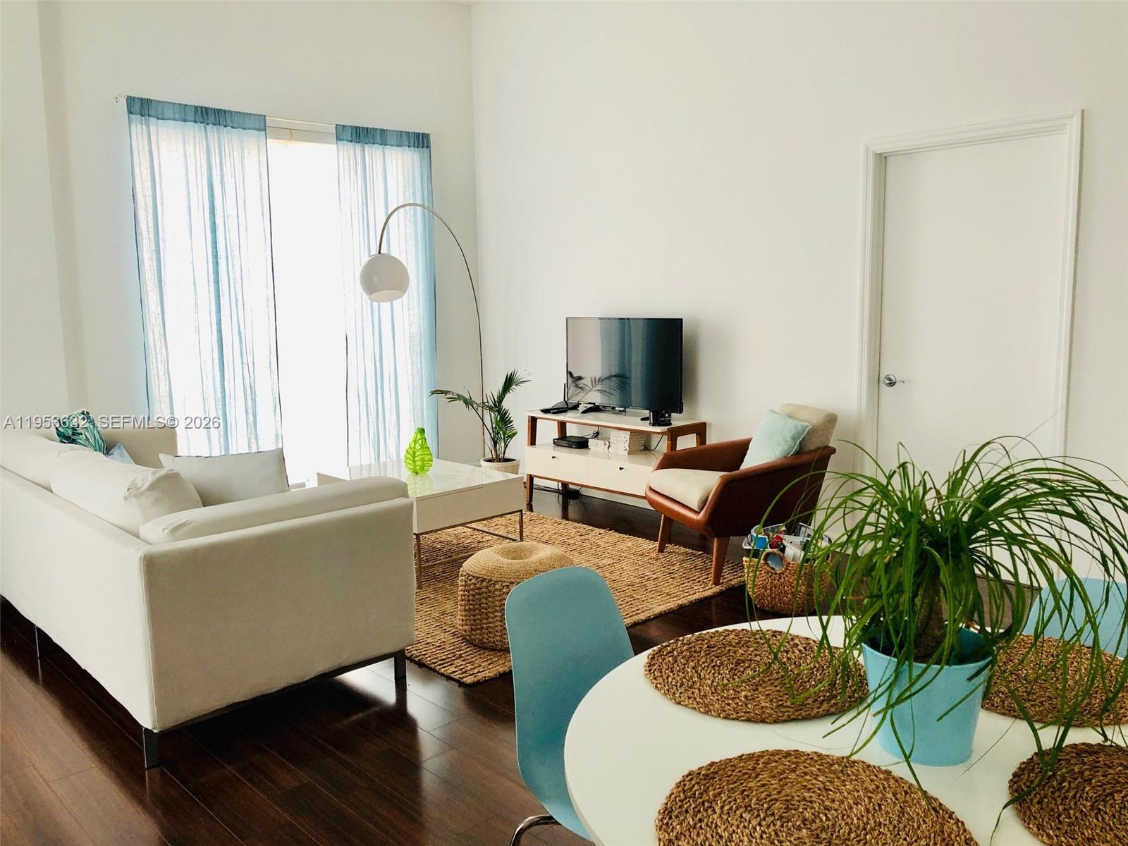 7290 Southwest 90th Street, Unit 701 Miami, FL 33156 - Photo 3 of 16 a living room with furniture and a flat screen tv