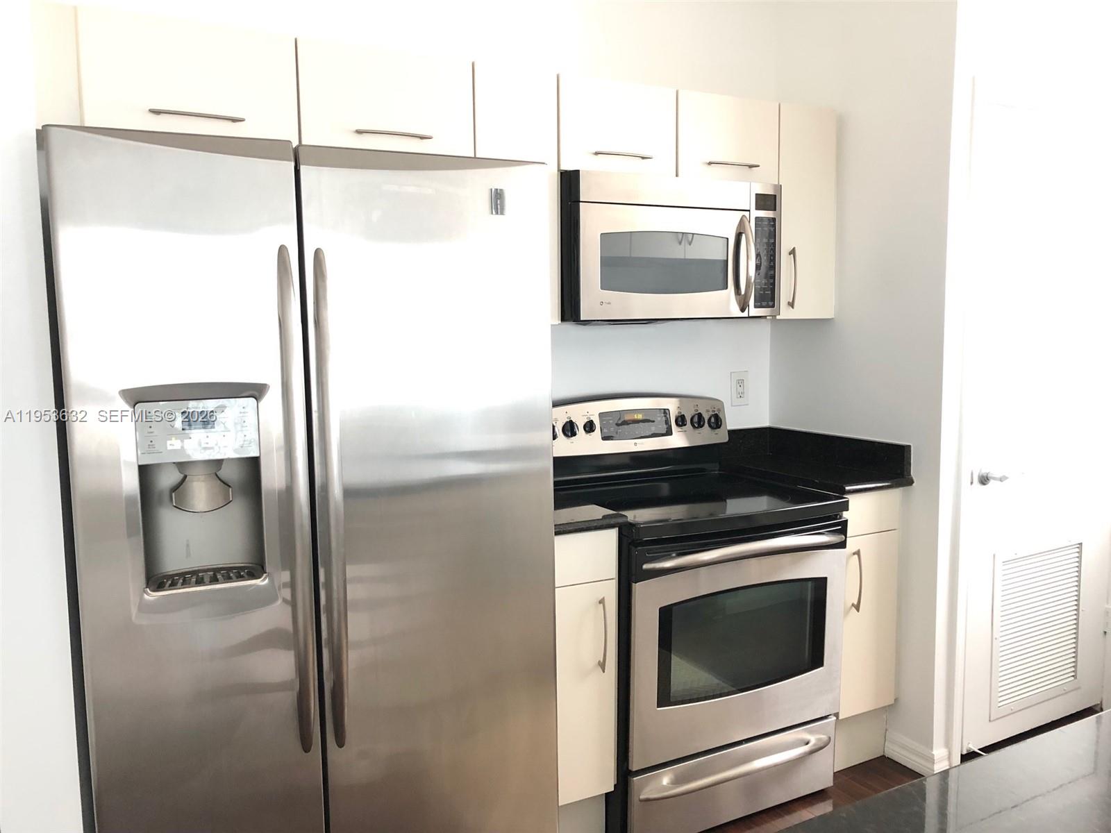 7290 Southwest 90th Street, Unit 701 Miami, FL 33156 - Photo 8 of 16 a kitchen with a stove and a refrigerator