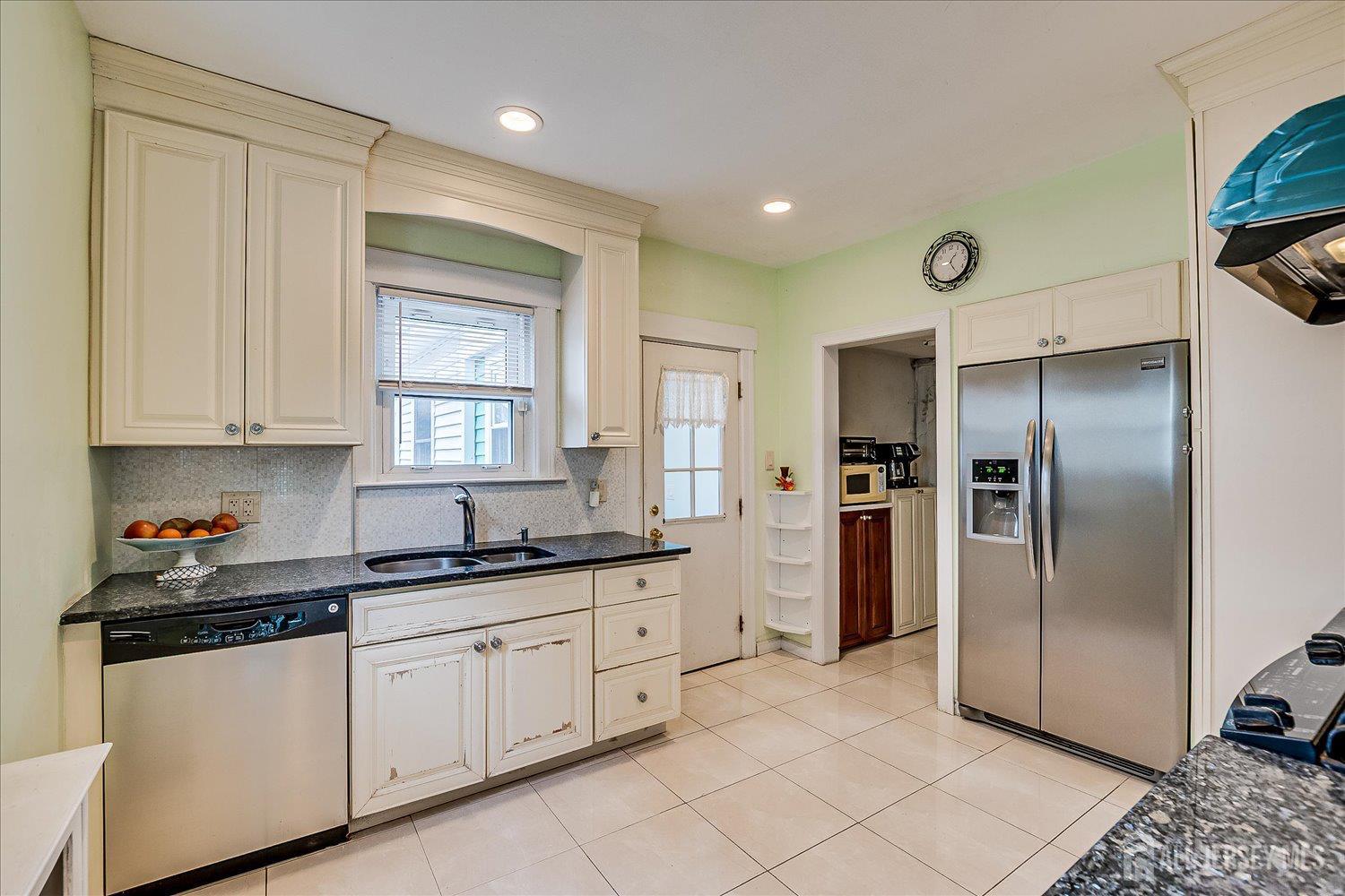 311 Prospect Avenue Dunellen, NJ 08812 - Photo 12 of 42 a kitchen with white cabinets and refrigerator
