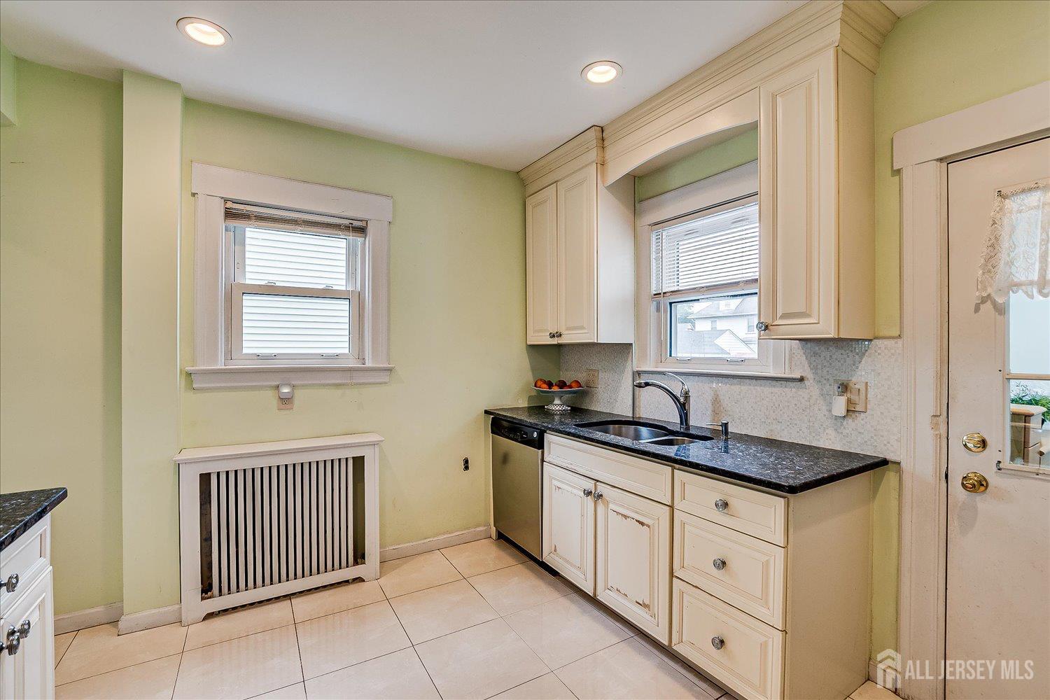 311 Prospect Avenue Dunellen, NJ 08812 - Photo 15 of 42 a kitchen with granite countertop white cabinets and window