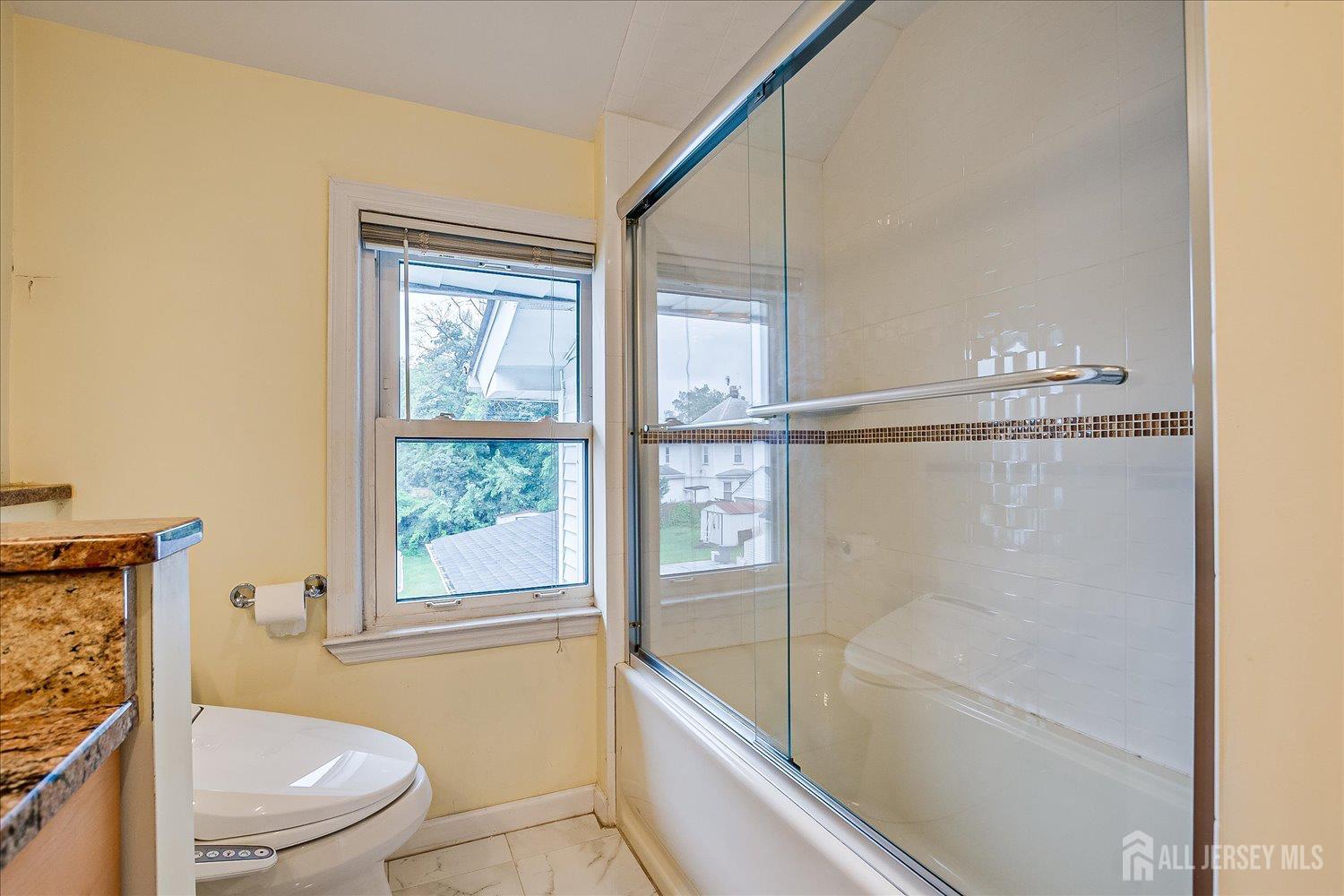 311 Prospect Avenue Dunellen, NJ 08812 - Photo 27 of 42 a bathroom with a granite countertop bathtub shower sink vanity and toilet