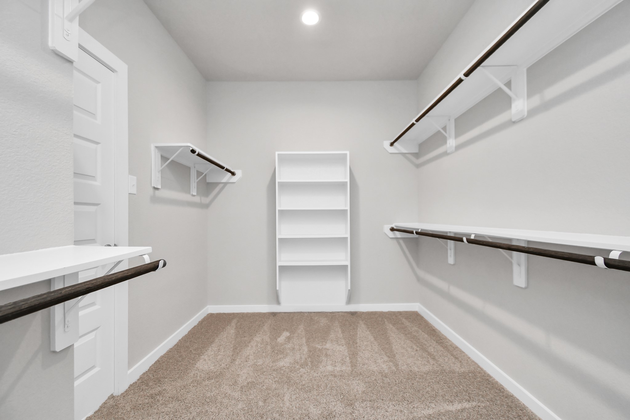 15111 Statice Trail Houston, TX 77044 - Photo 22 of 35 Expansive walk-in closet, adorned with high ceilings, luxurious carpet, and built in shelves. Sample photo of completed home with similar floor plan. Actual colors and selections may vary.