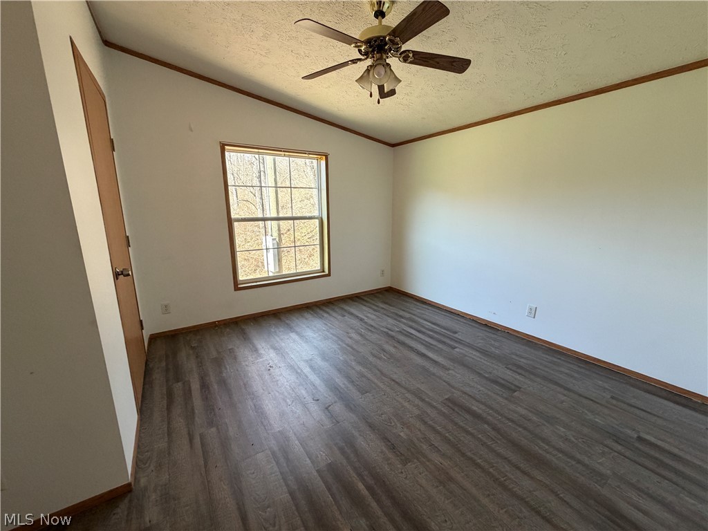 1285 Moody Hollow Road Blue Rock, OH 43720 - Photo 12 of 20 Empty room with ornamental molding, dark wood-type flooring, and ceiling fan