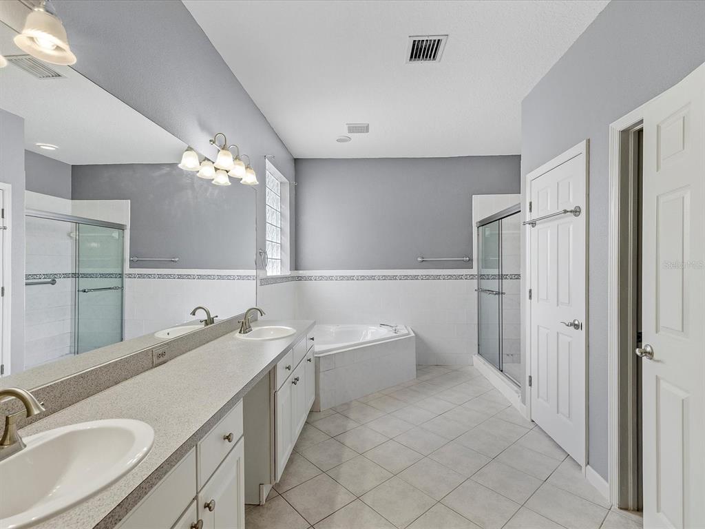 8551 Pratt Drive New Port Richey, FL 34654 - Photo 15 of 100 a bathroom with a double vanity sink mirror and bathtub