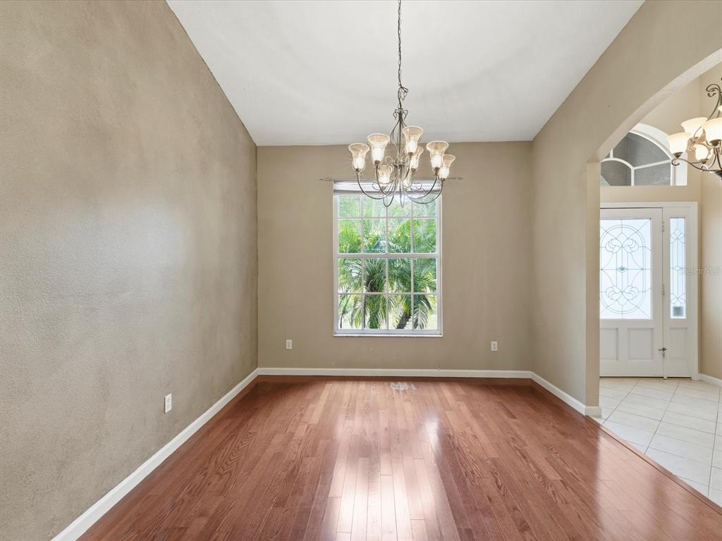 8551 Pratt Drive New Port Richey, FL 34654 - Photo 52 of 100 an empty room with wooden floor and chandelier