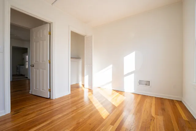 a view of a room with wooden floor and a hallway
