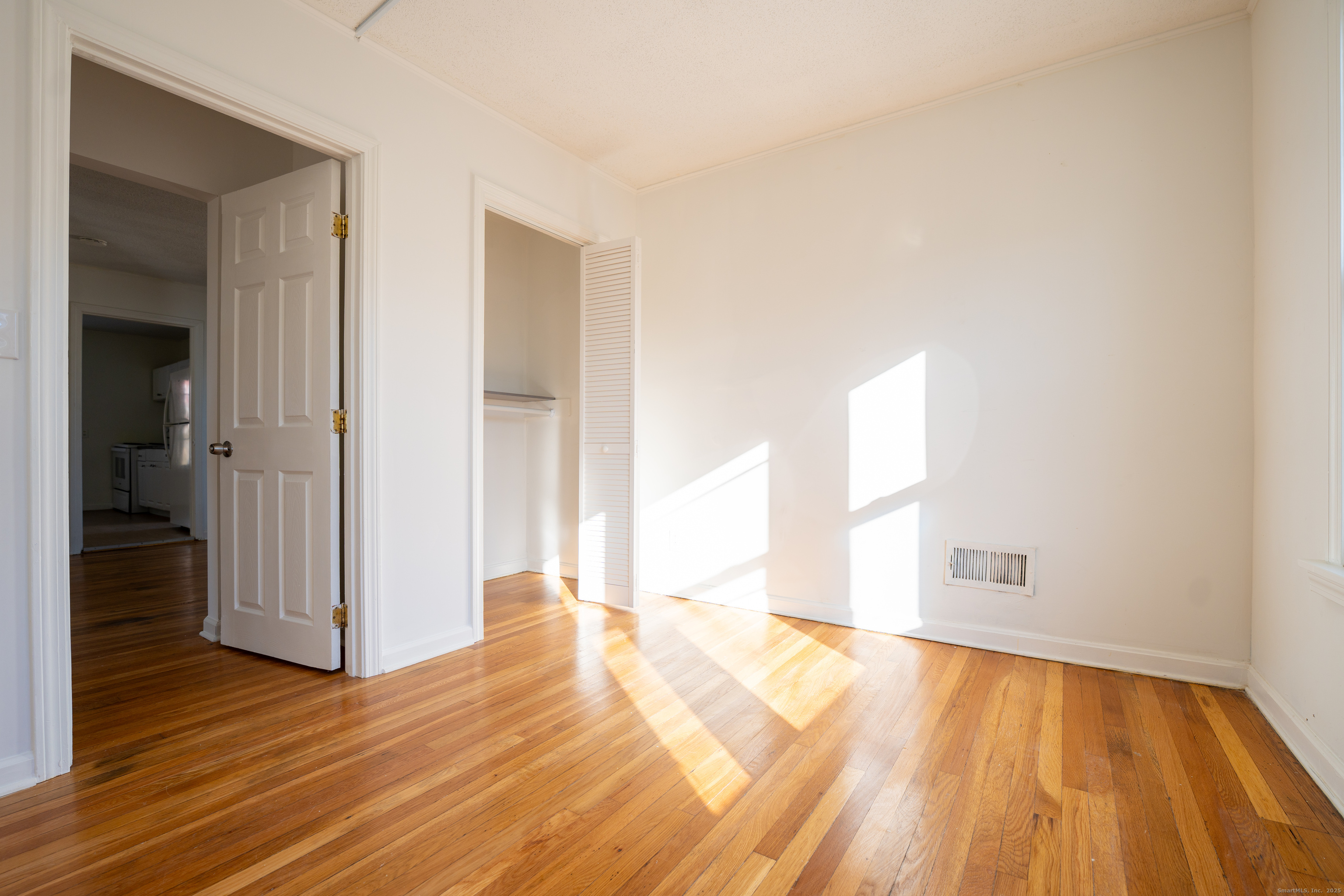 107 Columbia Street, Unit 2 New Britain, CT 06052 - Photo 5 of 9 a view of a room with wooden floor and a hallway
