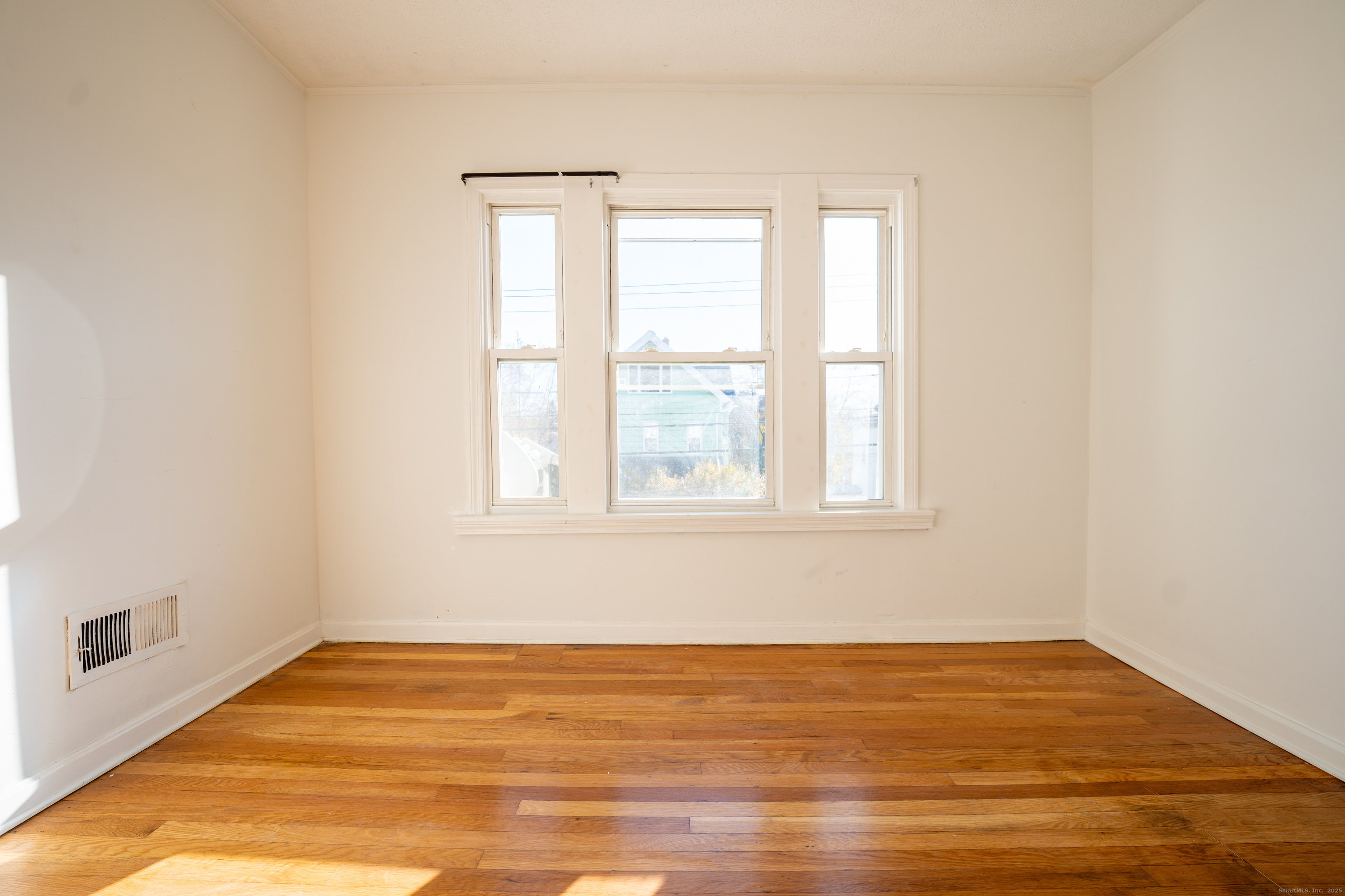 107 Columbia Street, Unit 2 New Britain, CT 06052 - Photo 6 of 9 a view of an empty room with wooden floor and a window