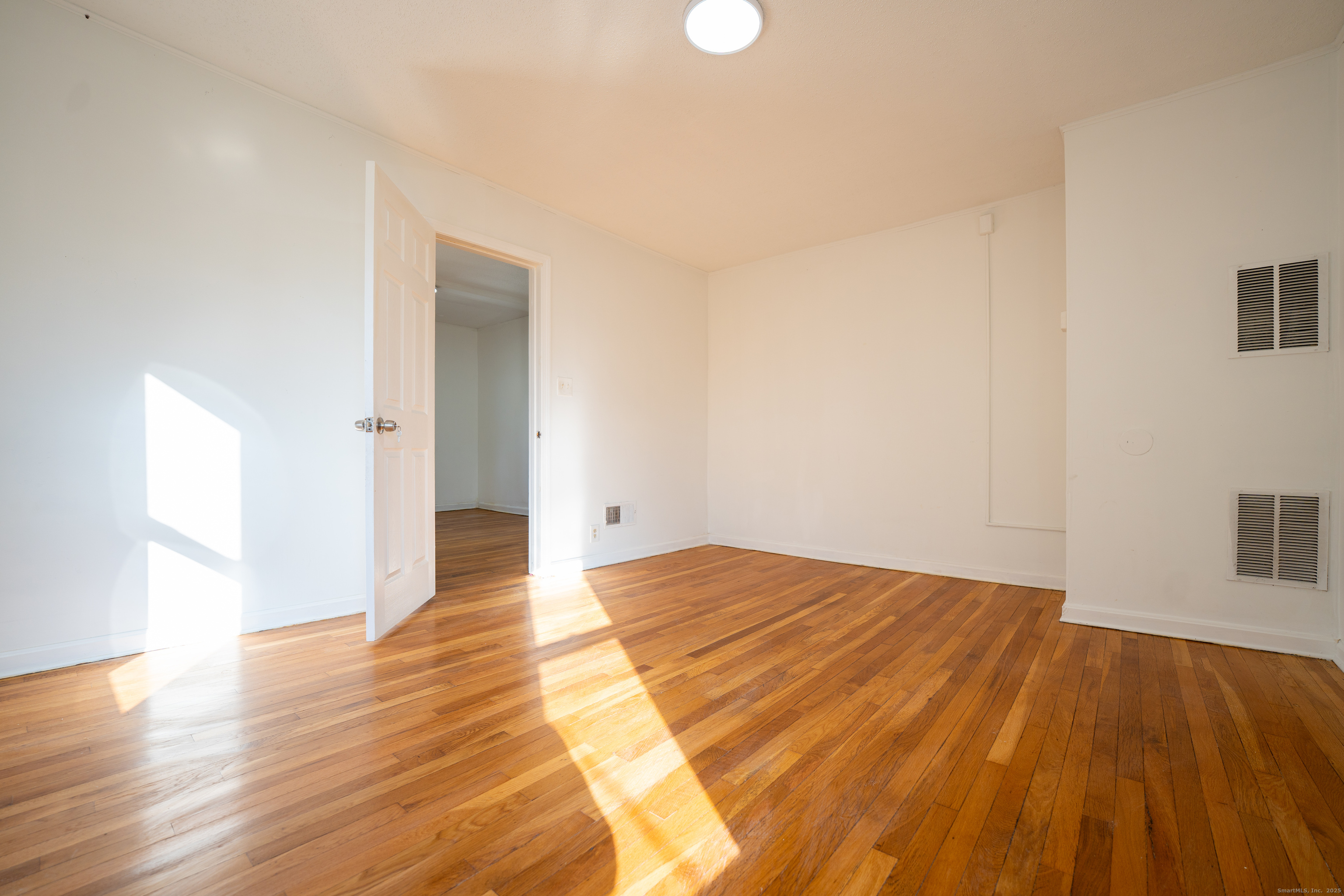 107 Columbia Street, Unit 2 New Britain, CT 06052 - Photo 8 of 9 a view of an empty room and wooden floor