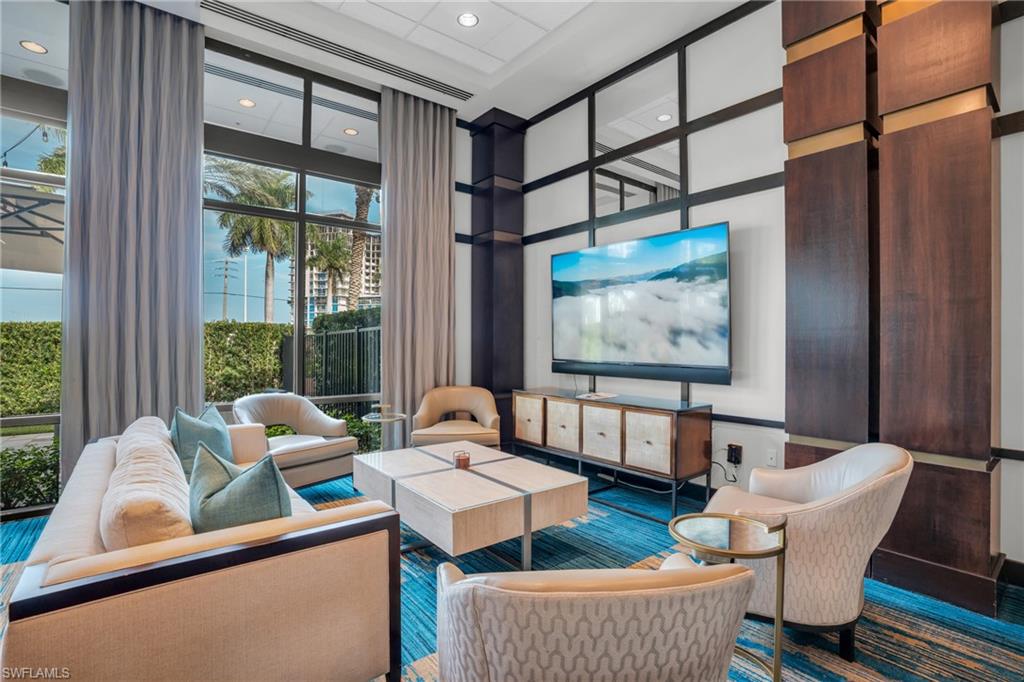 985 Sandpiper Street, Unit I103 Naples, FL 34102 - Photo 21 of 32 a living room with couches a coffee table and a large window with outer view